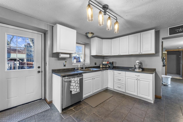 kitchen featuring pendant lighting, white cabinetry, sink, stainless steel dishwasher, and a textured ceiling