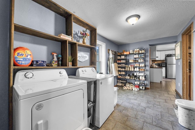 clothes washing area with a textured ceiling and independent washer and dryer