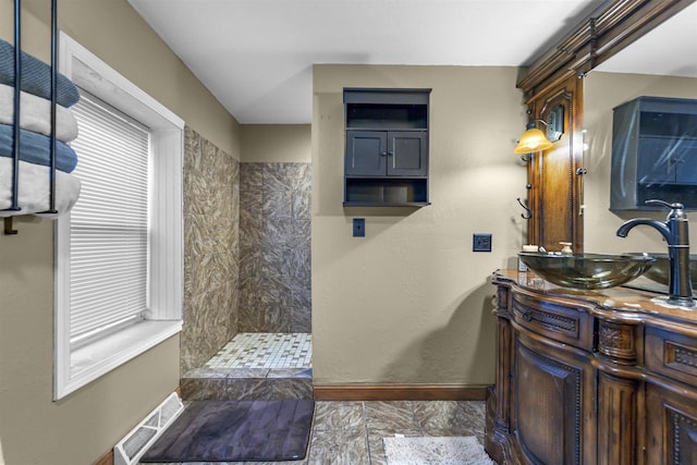 bathroom featuring vanity and tiled shower