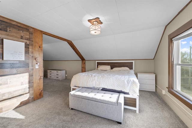 bedroom featuring vaulted ceiling, light colored carpet, and wooden walls