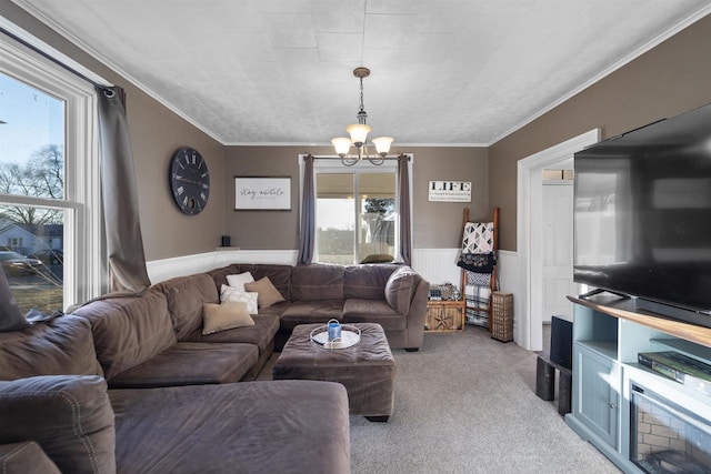 carpeted living room with crown molding, plenty of natural light, and a chandelier