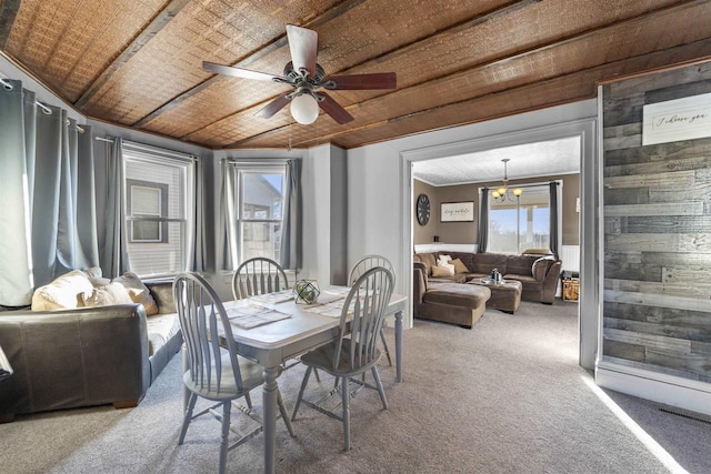 carpeted dining area with ornamental molding and ceiling fan with notable chandelier