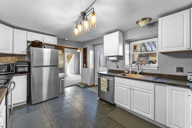 kitchen featuring white cabinetry, sink, stainless steel appliances, and a textured ceiling