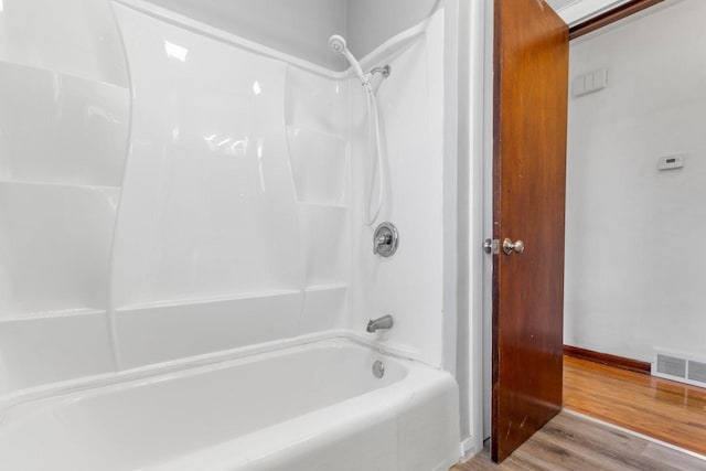 bathroom with wood-type flooring and shower / washtub combination