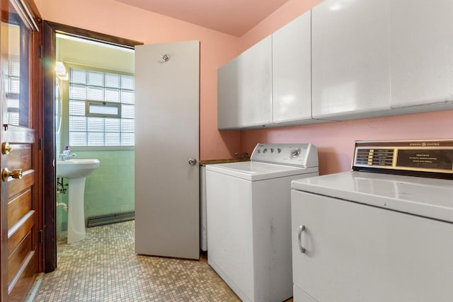 laundry room with cabinets, separate washer and dryer, and sink