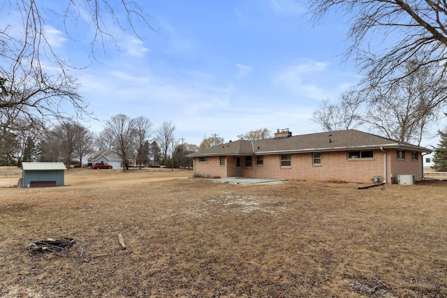 back of property featuring a patio and a shed