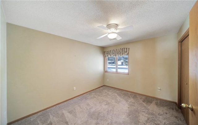 carpeted empty room with a textured ceiling and ceiling fan