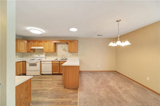 kitchen with sink, an inviting chandelier, hanging light fixtures, a textured ceiling, and white appliances