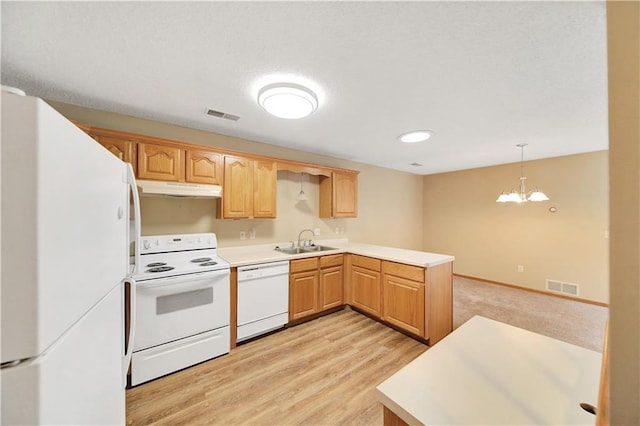 kitchen with pendant lighting, sink, kitchen peninsula, white appliances, and light hardwood / wood-style flooring