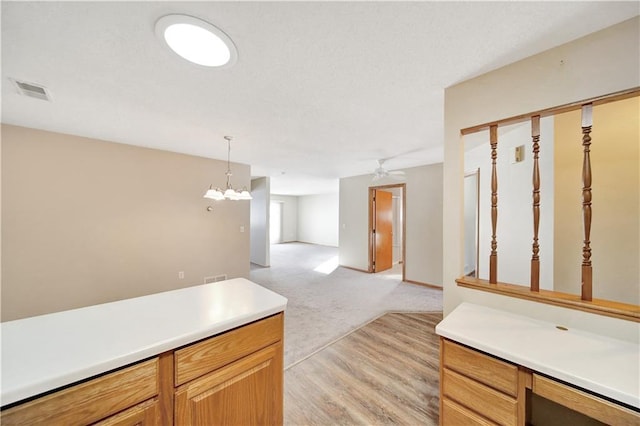 kitchen with pendant lighting, a notable chandelier, and light colored carpet