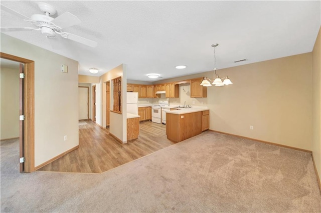 kitchen featuring sink, light carpet, kitchen peninsula, pendant lighting, and white appliances