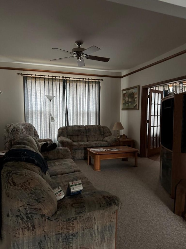 carpeted living room featuring plenty of natural light, ornamental molding, and ceiling fan