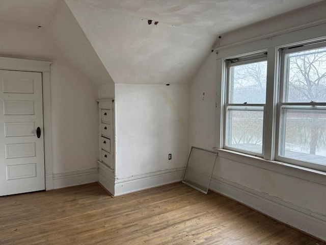 bonus room with vaulted ceiling and light hardwood / wood-style floors