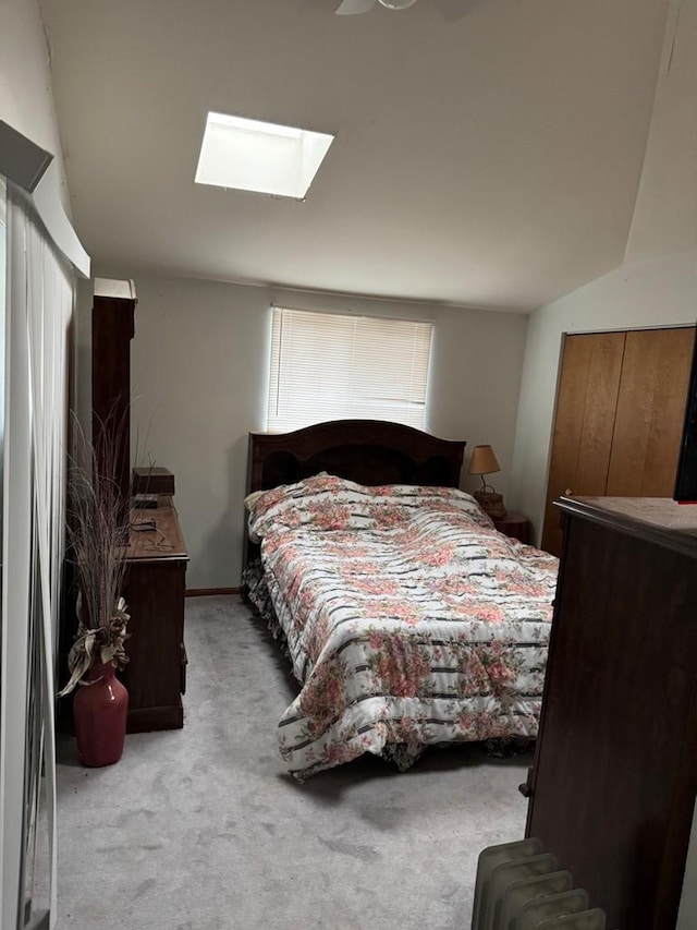 bedroom with a skylight and light colored carpet