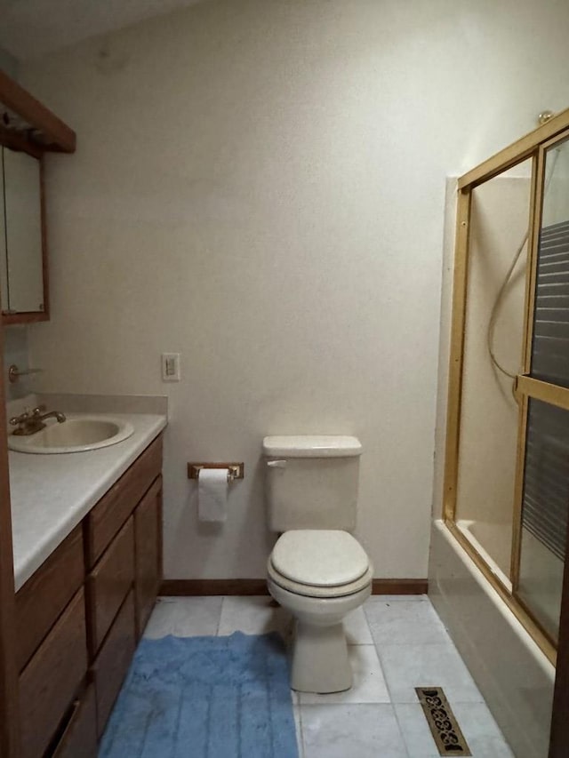 full bathroom with bath / shower combo with glass door, vanity, tile patterned floors, and toilet