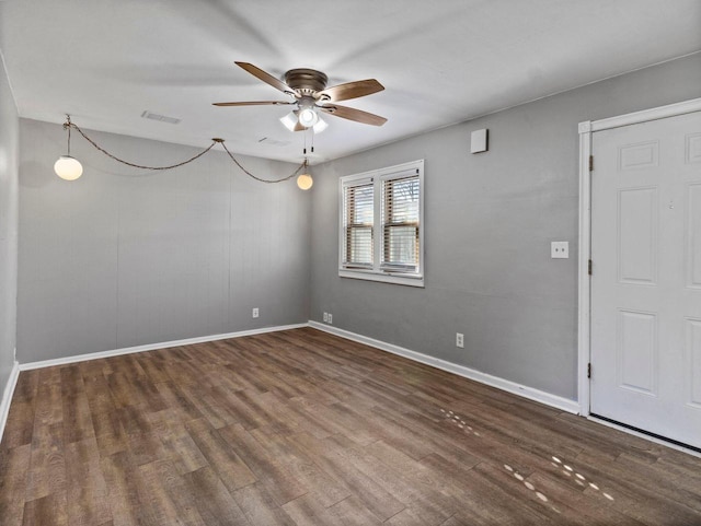 spare room with dark wood-type flooring and ceiling fan