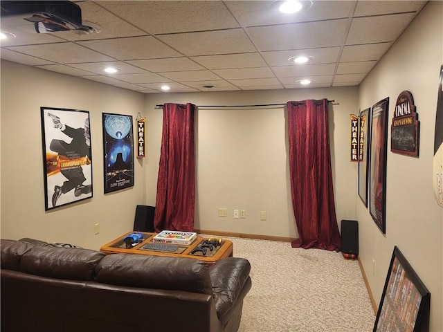 cinema room with a drop ceiling and carpet flooring