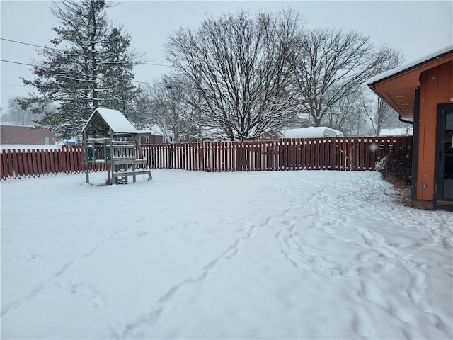 yard covered in snow with a playground