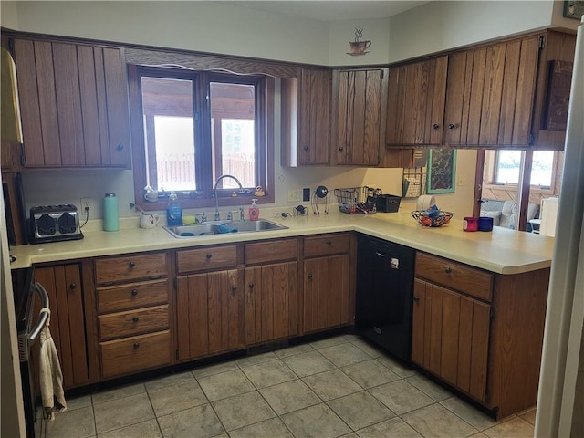 kitchen featuring dishwasher, sink, dark brown cabinetry, and kitchen peninsula