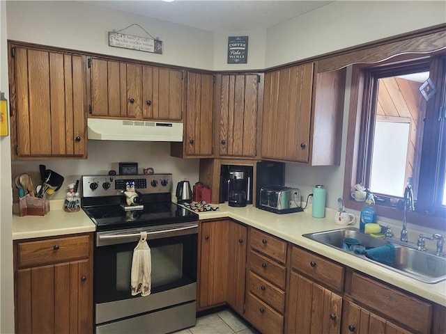 kitchen with light tile patterned flooring, sink, and stainless steel range with electric cooktop