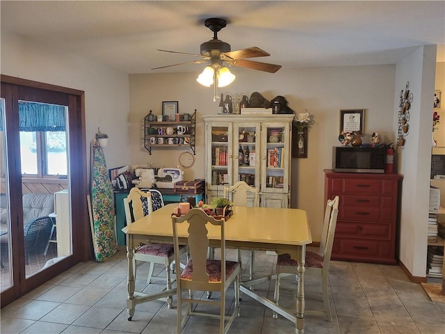 tiled dining space featuring ceiling fan