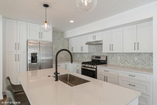 kitchen with appliances with stainless steel finishes, sink, hanging light fixtures, and white cabinetry