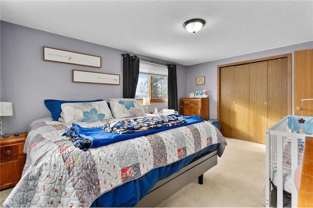 carpeted bedroom with a closet and a textured ceiling