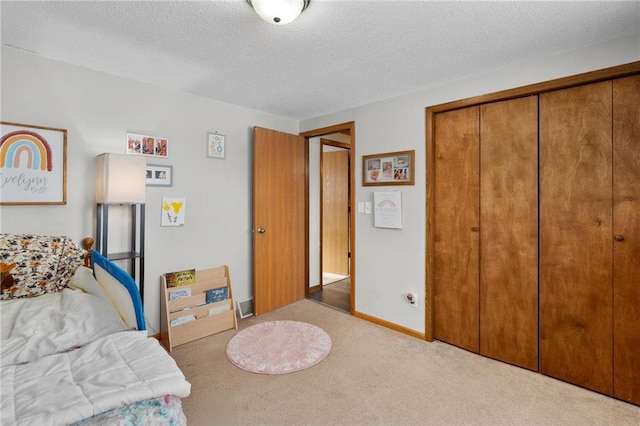 bedroom featuring light colored carpet, a closet, and a textured ceiling