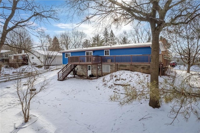 snow covered house with a deck