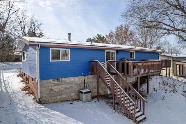 snow covered house with a deck