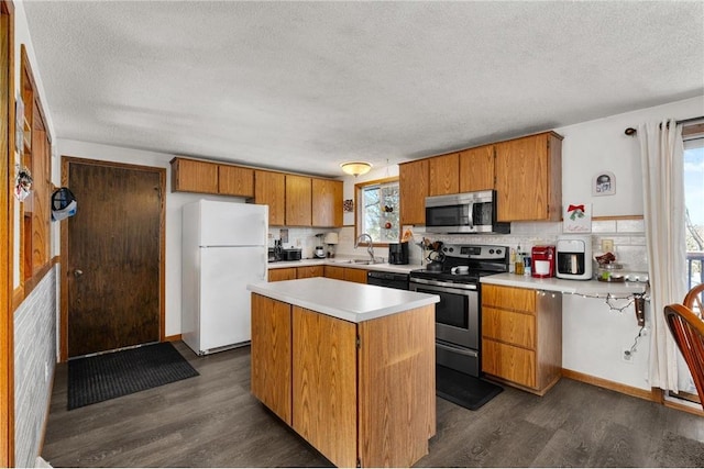 kitchen featuring sink, stainless steel appliances, a center island, tasteful backsplash, and dark hardwood / wood-style flooring