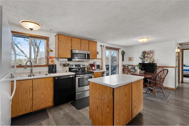 kitchen featuring sink, tasteful backsplash, dark hardwood / wood-style flooring, a kitchen island, and stainless steel appliances