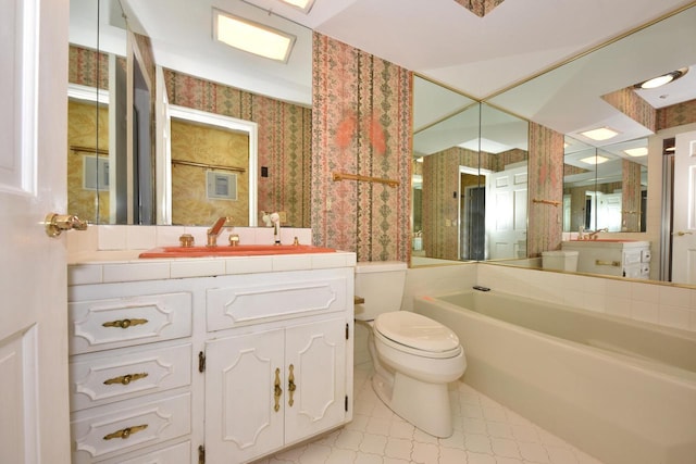 bathroom featuring a washtub, vanity, and toilet