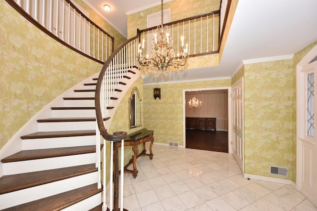 stairs featuring a notable chandelier, crown molding, and a towering ceiling