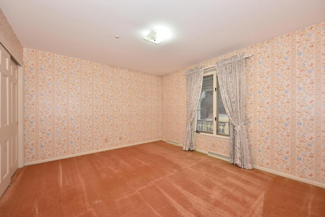 spare room with carpet floors and a baseboard radiator