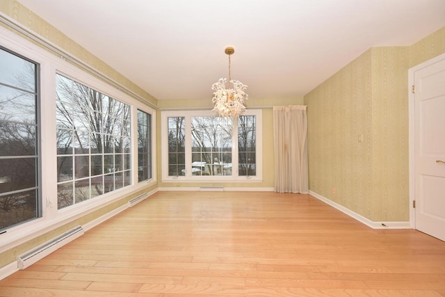 unfurnished sunroom featuring a baseboard heating unit and a notable chandelier