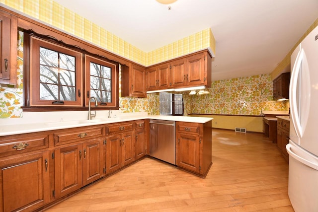 kitchen featuring sink, white refrigerator, stainless steel dishwasher, kitchen peninsula, and light hardwood / wood-style floors