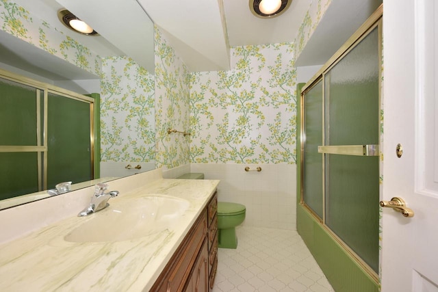 full bathroom featuring vanity, bath / shower combo with glass door, and toilet