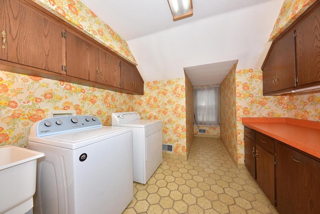 laundry area featuring independent washer and dryer, sink, and cabinets