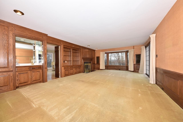 unfurnished living room with built in features and light colored carpet