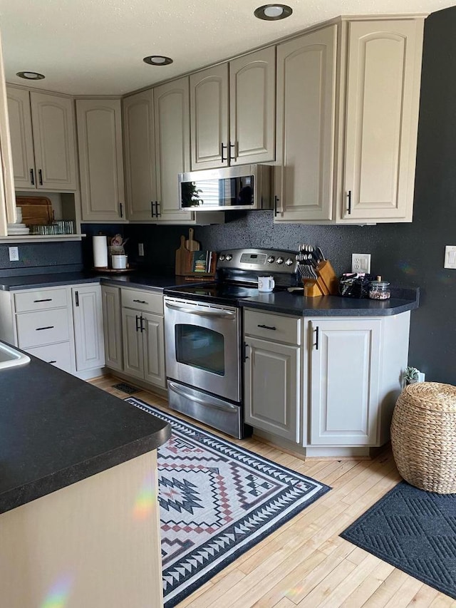 kitchen featuring light hardwood / wood-style flooring, gray cabinets, and appliances with stainless steel finishes