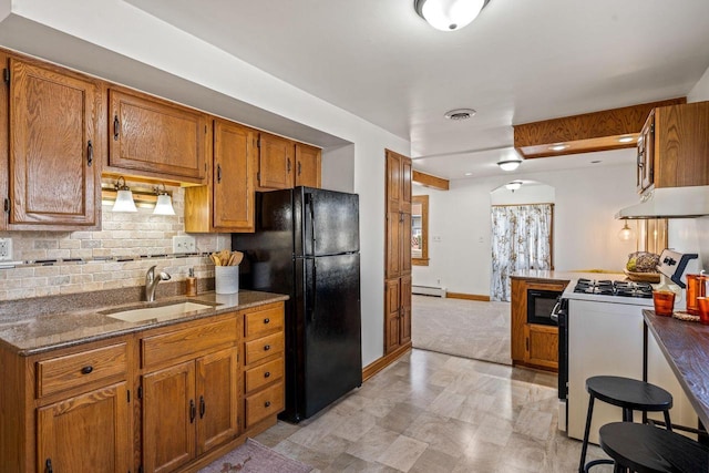 kitchen with a baseboard radiator, sink, decorative backsplash, and black appliances