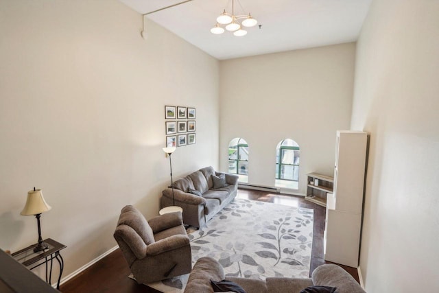 living room featuring an inviting chandelier, a baseboard radiator, dark hardwood / wood-style floors, and a high ceiling