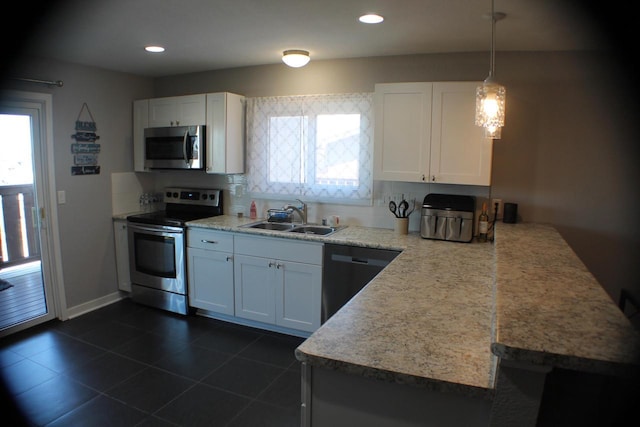 kitchen featuring stainless steel appliances, hanging light fixtures, sink, and white cabinets