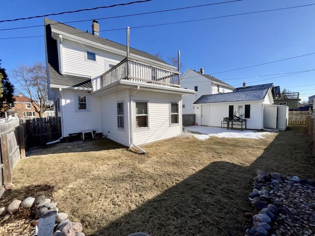 rear view of property featuring an outbuilding, a patio, and a balcony