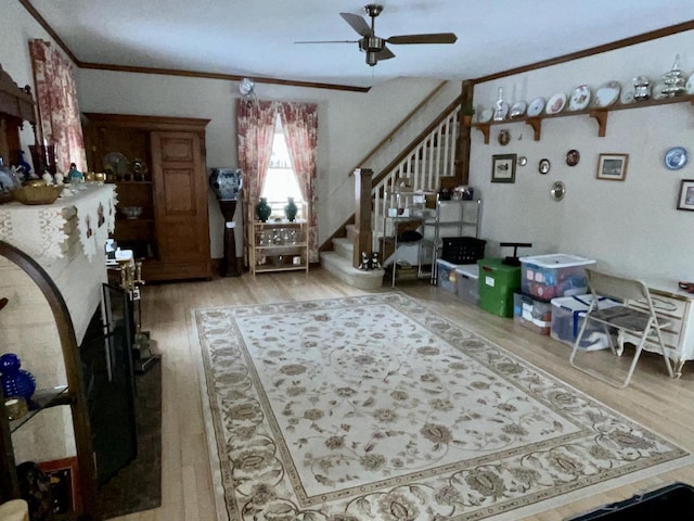 living room with crown molding, wood-type flooring, and ceiling fan