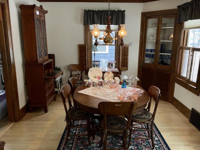 dining space featuring a notable chandelier and light wood-type flooring