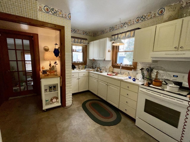 kitchen with sink, hanging light fixtures, electric range, backsplash, and white cabinets