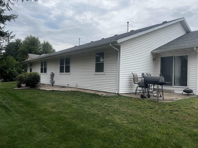 view of side of home featuring a yard and a patio area