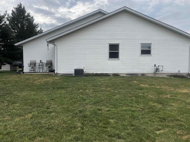 view of home's exterior with central AC unit and a lawn